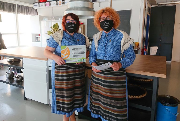 Kaksi Martta-yhdistyksen jäsentä yhteisötilan keittiössä, maskit kasvoilla