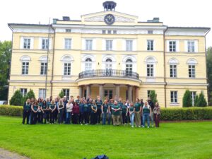 ryhmäkuva nuoriso-opintomatkalta, taustalla vuojoen kartano